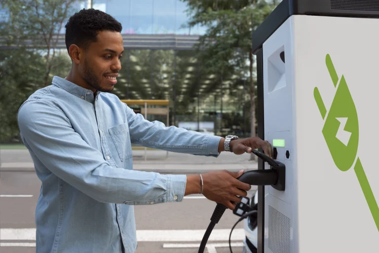 Homme utilisant une borne de recharge électrique pour sa voiture